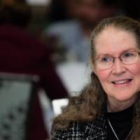 A women smiles during round table discussions.